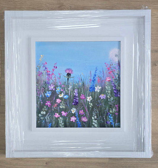 Framed artwork of a field of colorful flowers with a white frame.