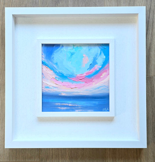 Framed abstract coastal painting with blue and pink hues