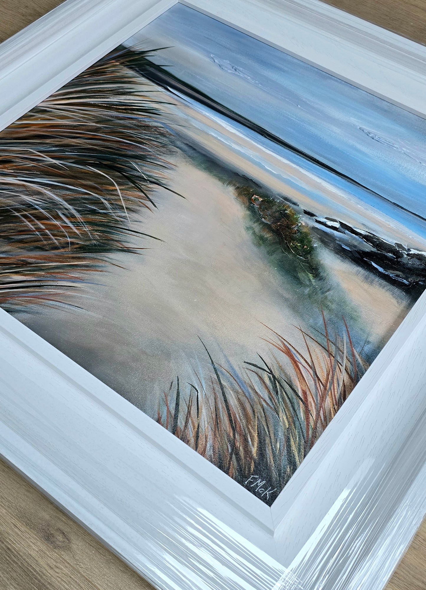 Framed artwork of a beach scene.