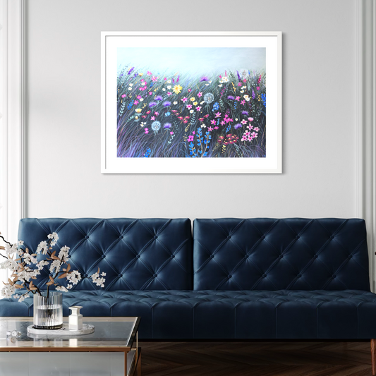 Framed artwork of a colorful floral scene above a blue sofa in a living room.