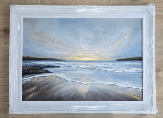 Framed painting of a beach scene with a sunset and cloudy sky.