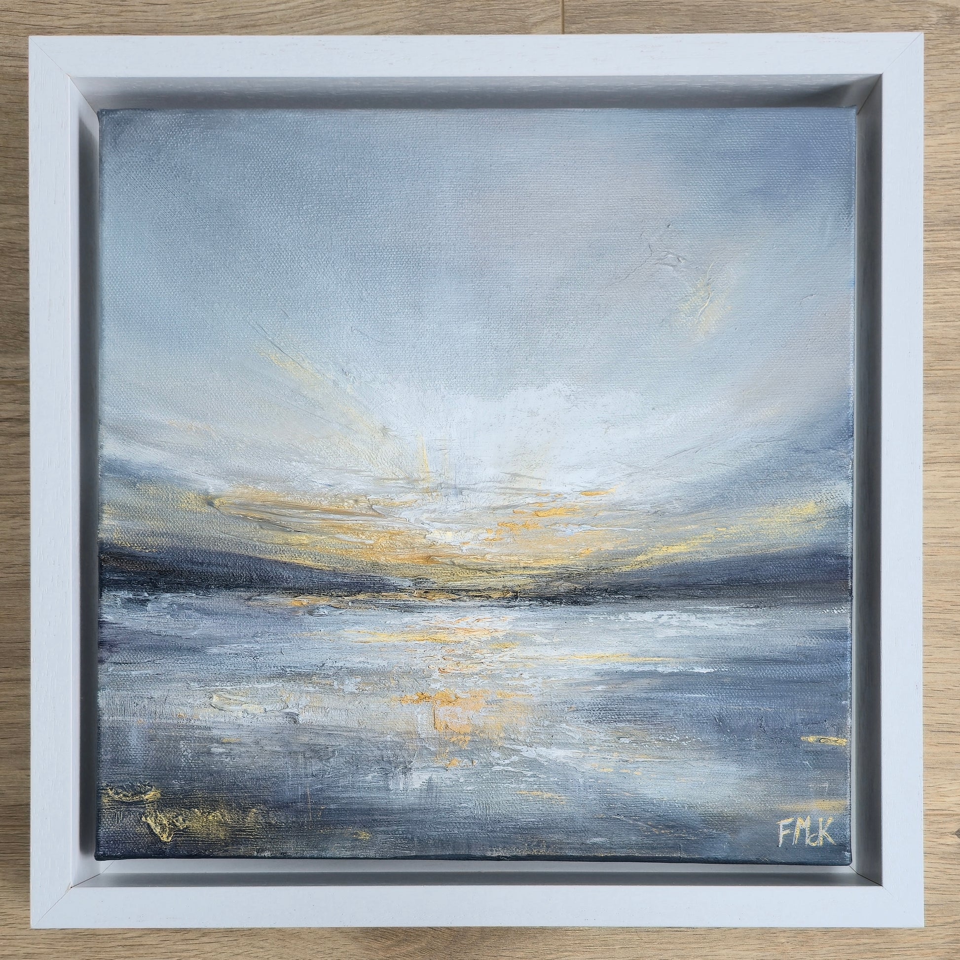 Framed painting of a sunset along the coast