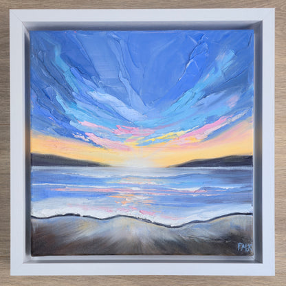 Framed painting of a sunset over the coast