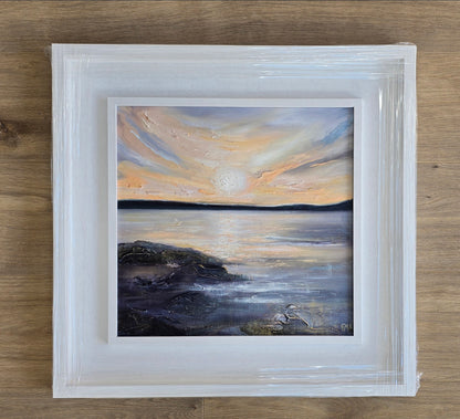 Framed painting of a sunset over water 