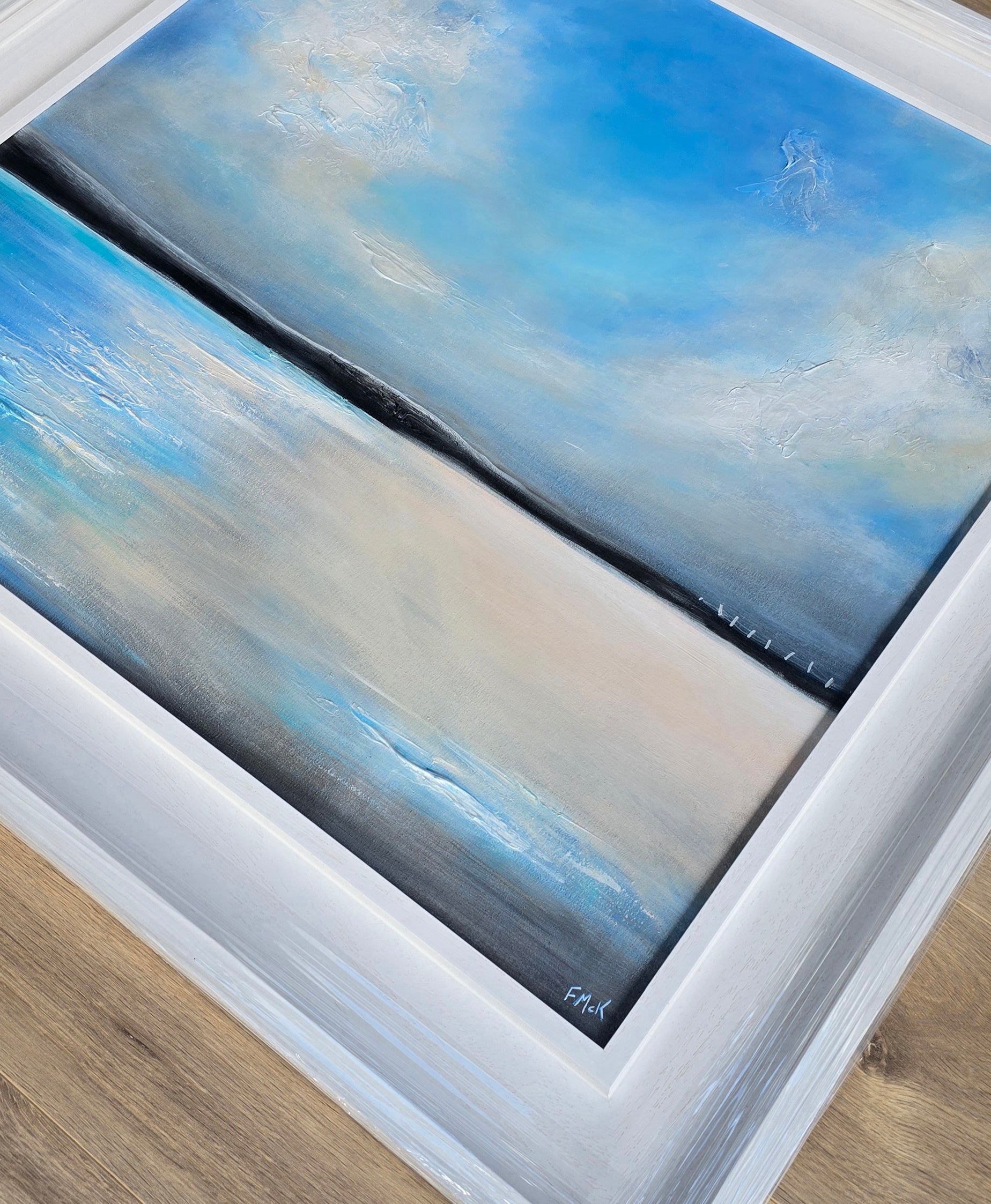 Abstract painting with blue and beige tones on a wooden surface