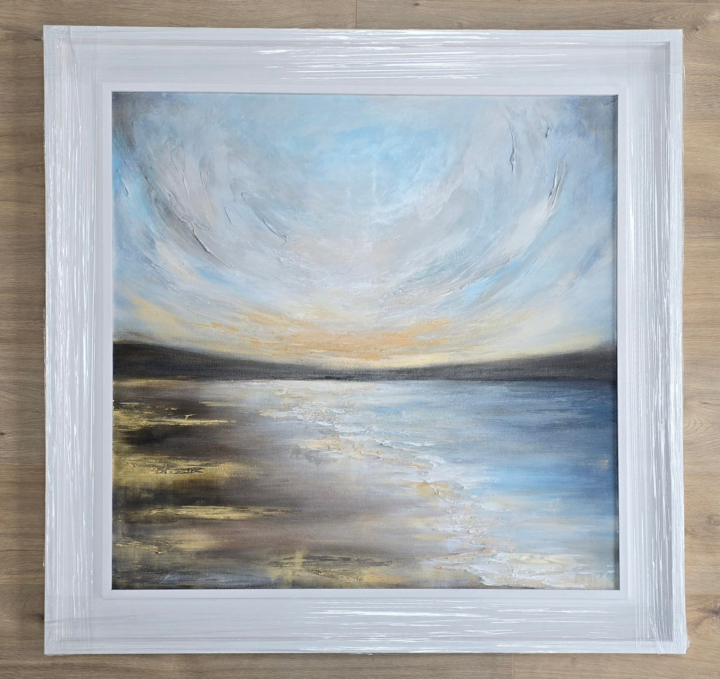Golden sunset painting in a white frame