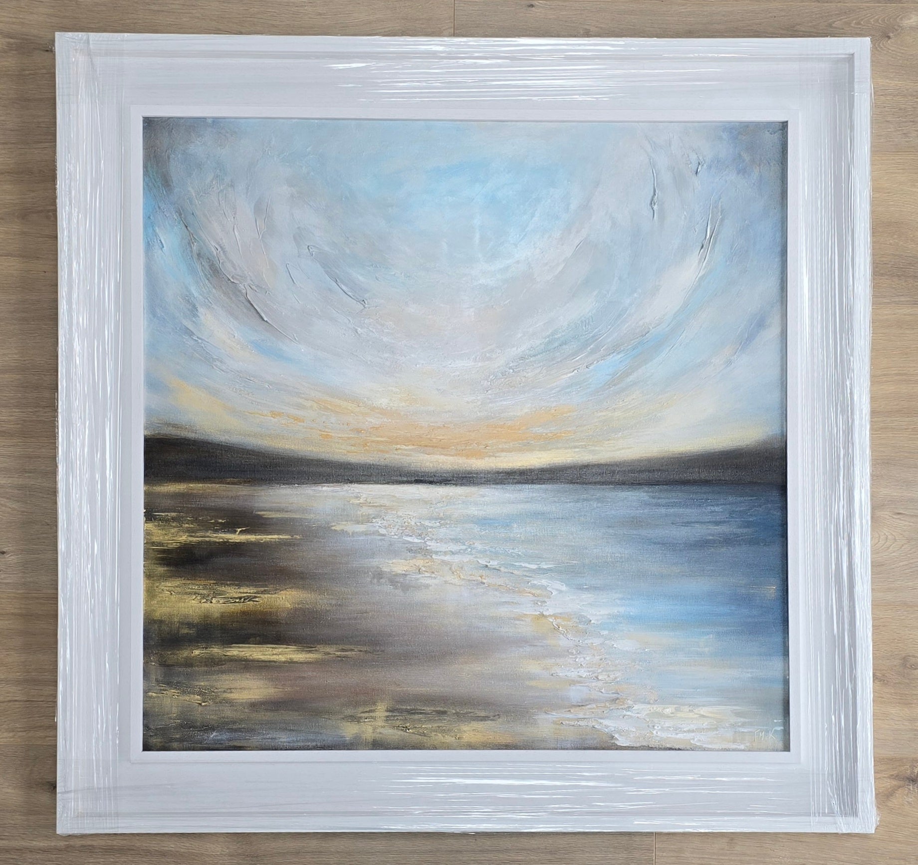 Golden sunset painting in a white frame