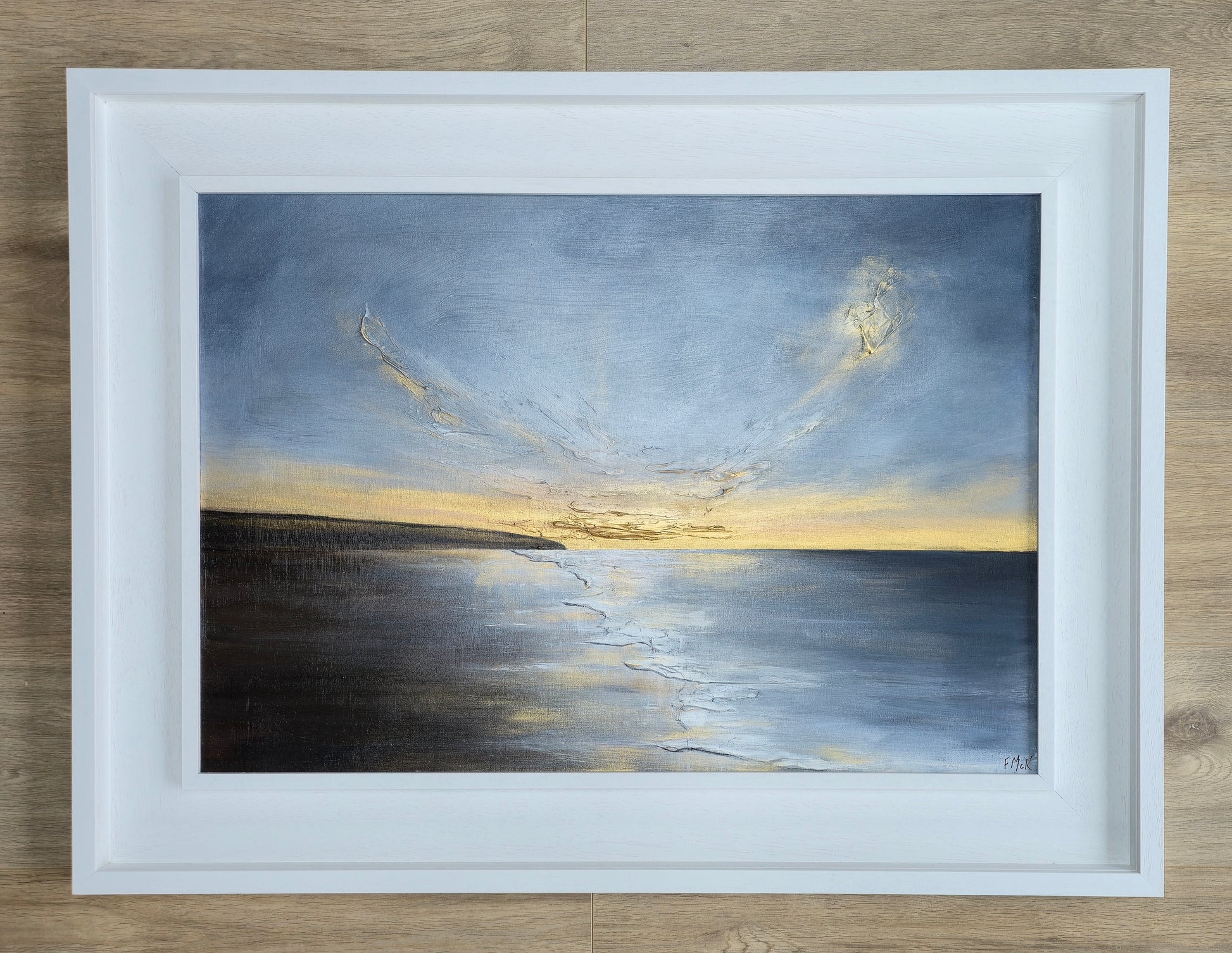 Framed artwork of a sunset at the coast