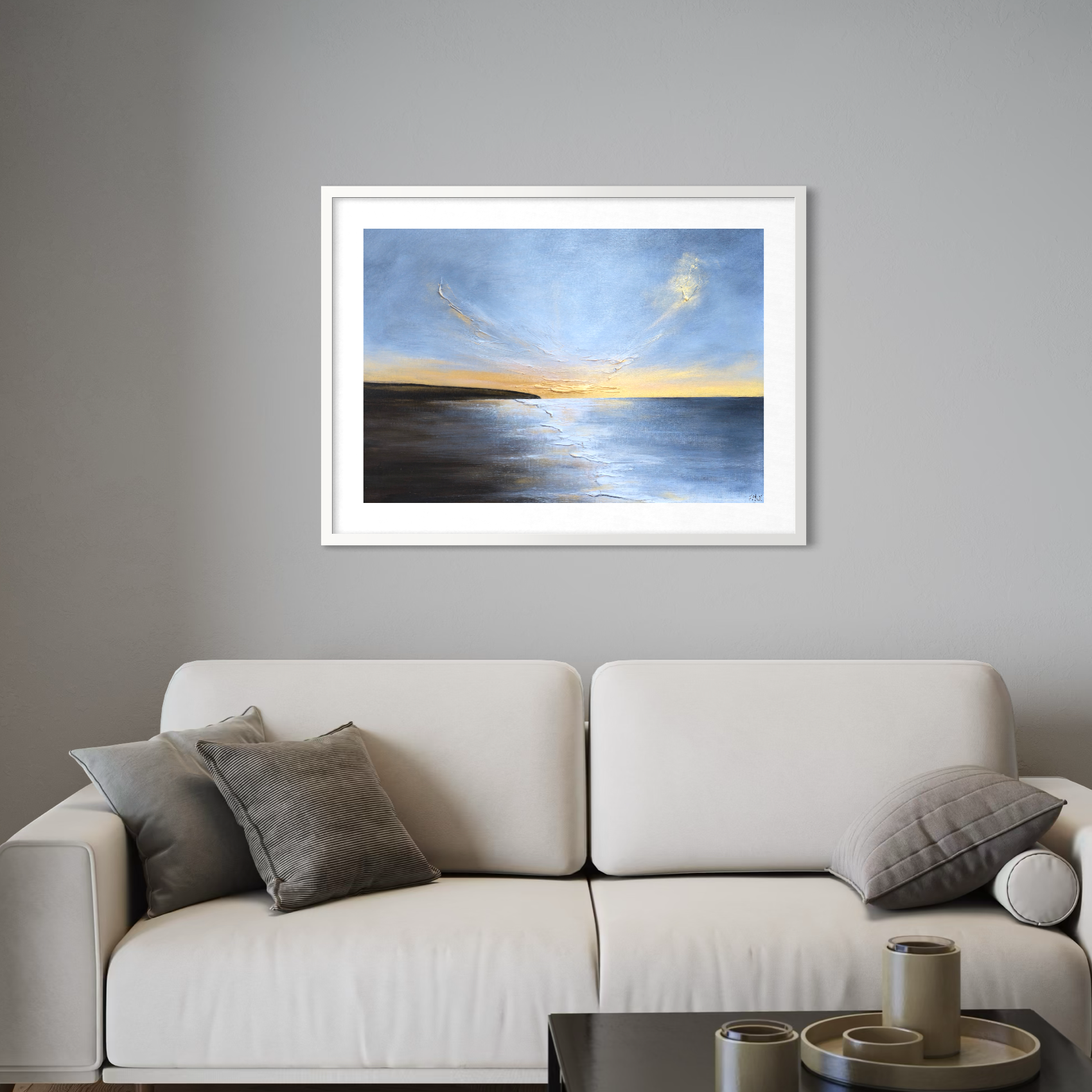 Framed artwork above a beige sofa with gray cushions in a living room setting.
