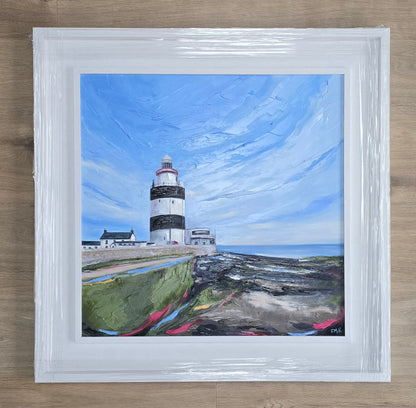 Framed painting of Hook lighthouse with a blue sky and ocean.