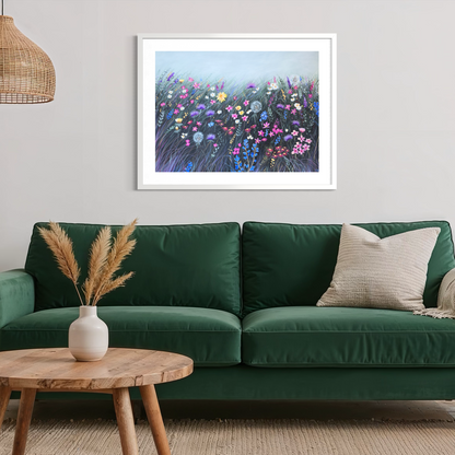 Framed artwork of a floral scene above a green sofa in a living room.