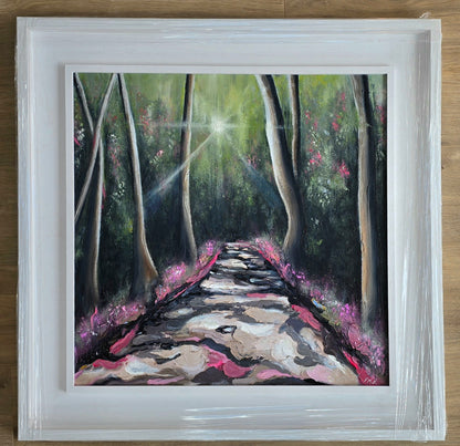 Framed painting of a forest path with sunlight filtering through the trees