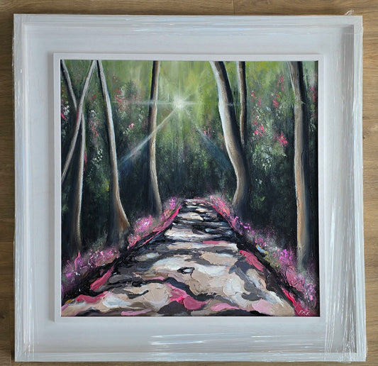 Framed painting of a forest path with sunlight filtering through the trees