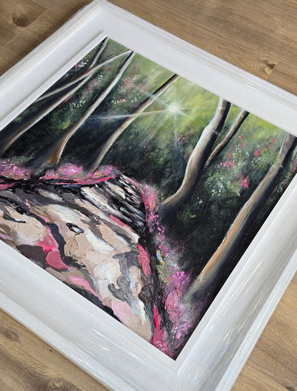 Framed painting of a natural scene with trees and pink flowers