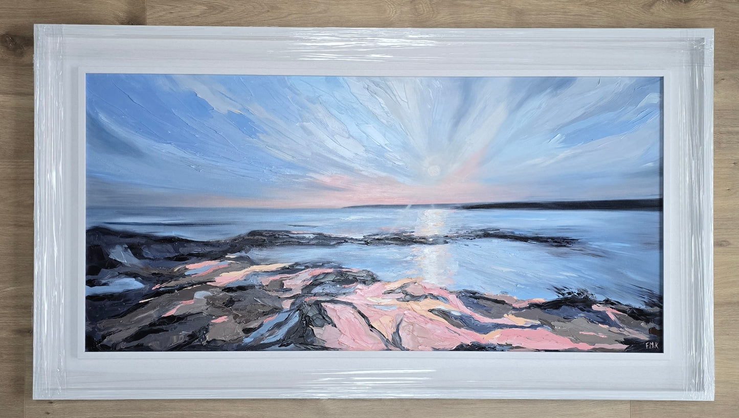 Framed painting of a coastal scene with a blue sky and rocky shore.