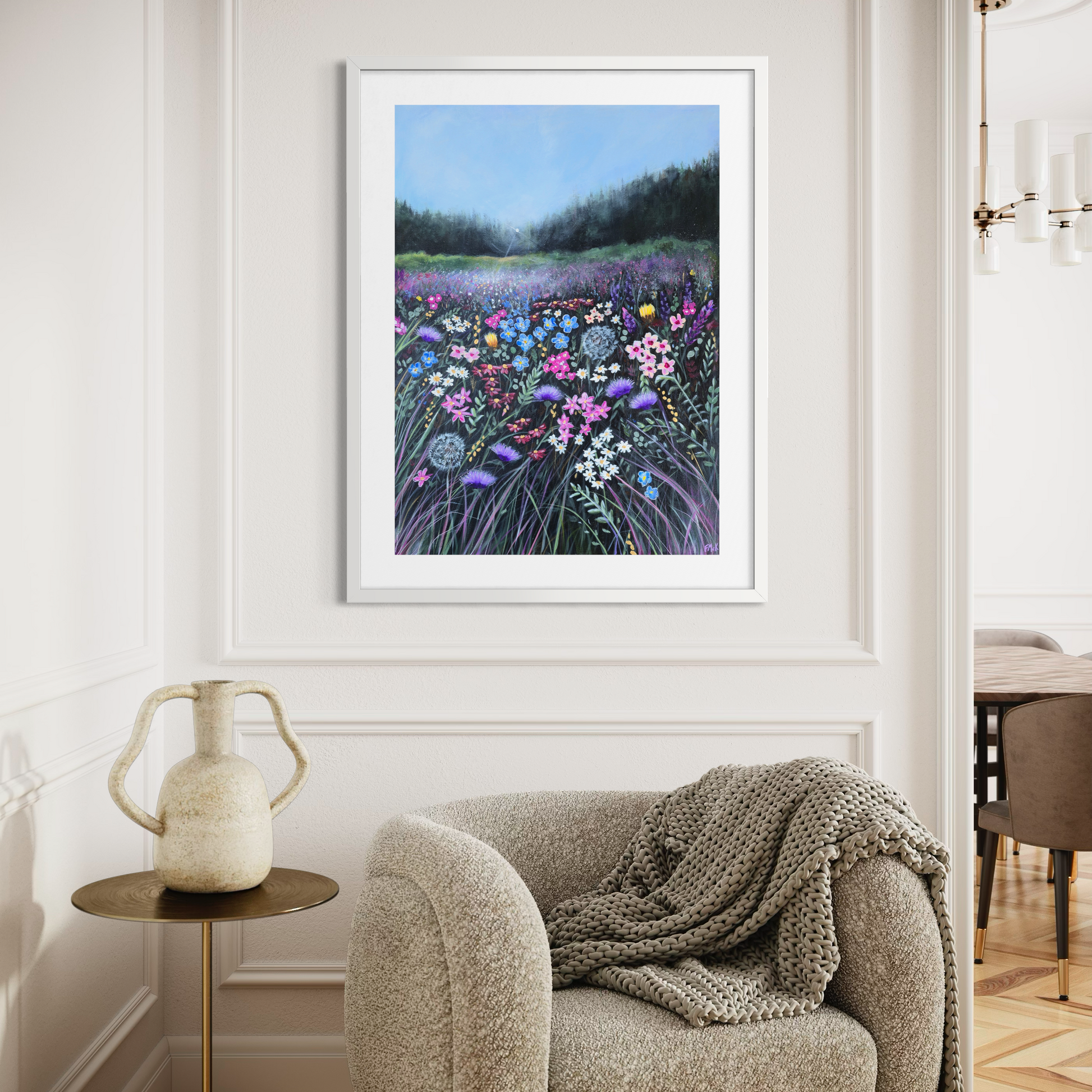 Framed artwork of a floral landscape on a wall above a sofa.