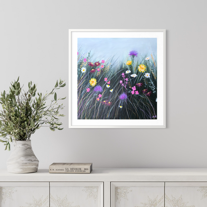 Framed artwork of a colorful floral scene on a wall above a white cabinet.